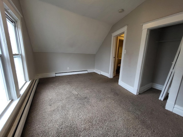 additional living space with a baseboard heating unit, lofted ceiling, and carpet