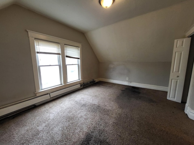 additional living space with a baseboard heating unit, vaulted ceiling, baseboards, and carpet floors