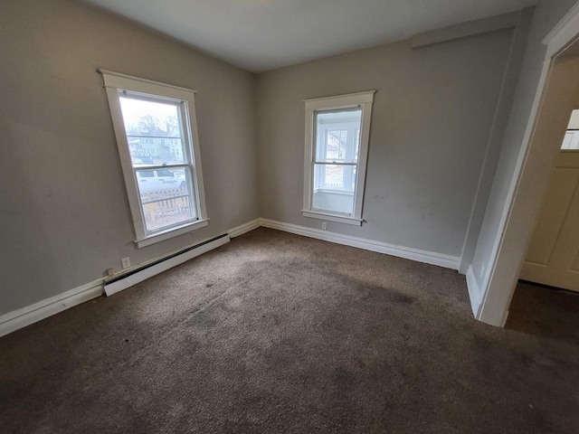 empty room with baseboards, baseboard heating, and dark carpet