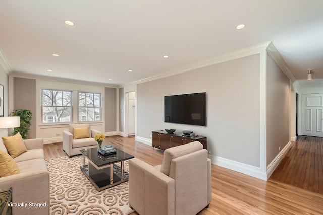 living area with crown molding, light wood-style floors, and baseboards