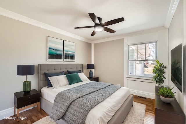 bedroom featuring crown molding, wood finished floors, and baseboards