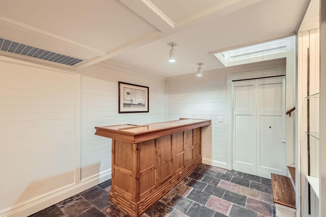 bar with visible vents, stone tile floors, and crown molding