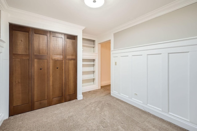 unfurnished bedroom with light carpet, ornamental molding, and a decorative wall