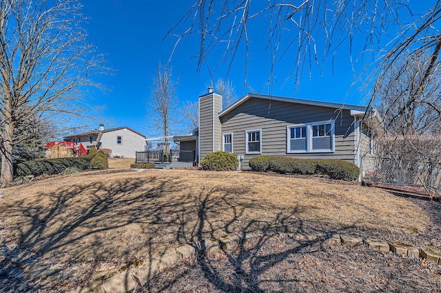 exterior space with a wooden deck and a chimney