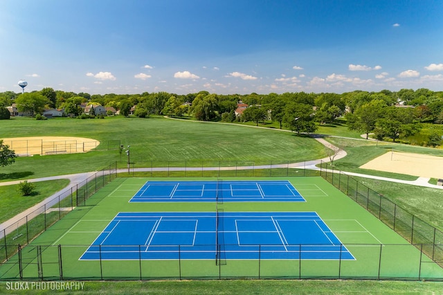 view of sport court featuring a lawn and fence