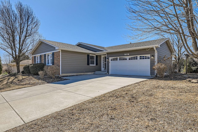 single story home with a garage, brick siding, and concrete driveway