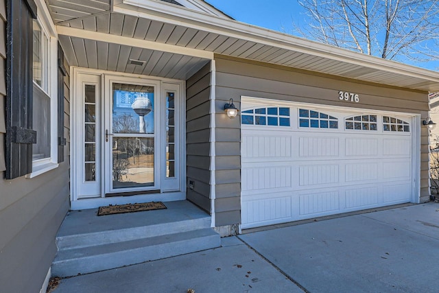 view of exterior entry featuring concrete driveway