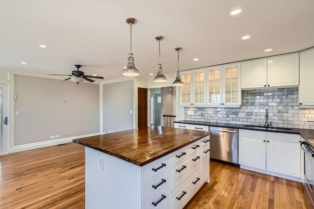 kitchen with stainless steel dishwasher, light wood-style flooring, butcher block countertops, and a sink