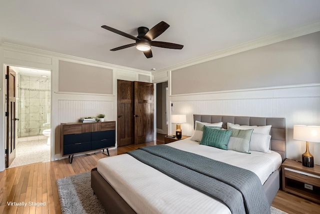 bedroom with a closet, a wainscoted wall, crown molding, and hardwood / wood-style flooring