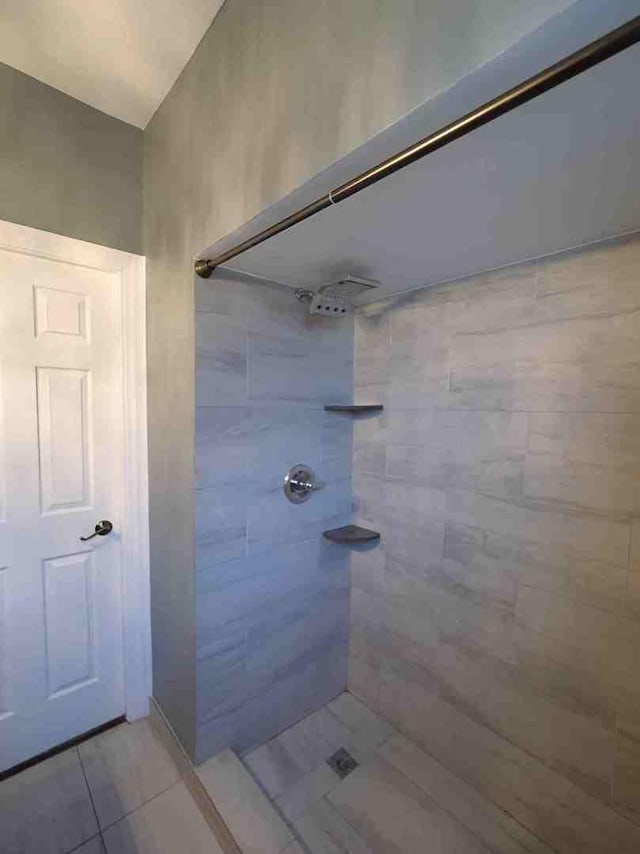 bathroom with tile patterned floors and a tile shower