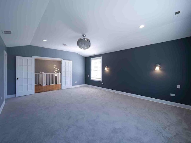 interior space with visible vents, baseboards, carpet flooring, and vaulted ceiling