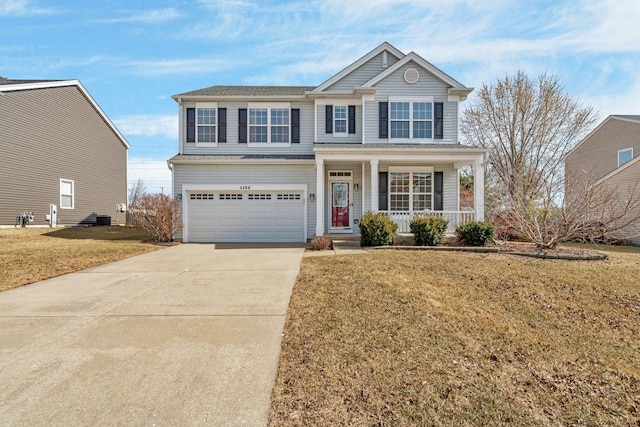 traditional-style home featuring concrete driveway, an attached garage, covered porch, and a front lawn