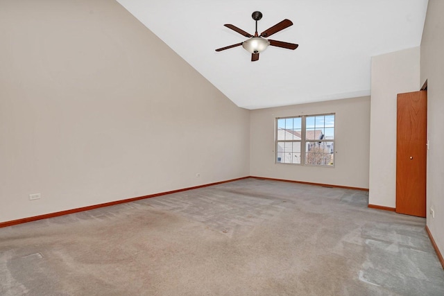 carpeted empty room featuring lofted ceiling, baseboards, and ceiling fan