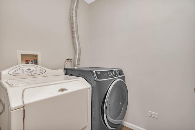 laundry room with baseboards, independent washer and dryer, and laundry area