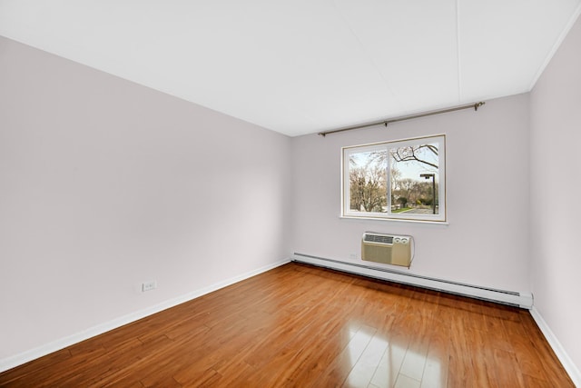 unfurnished room featuring baseboards, a wall unit AC, wood finished floors, and a baseboard radiator