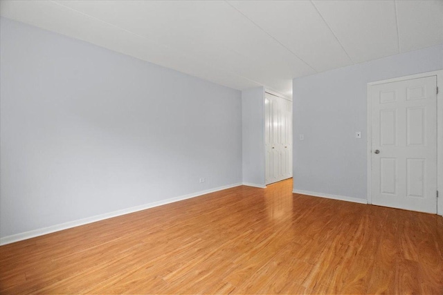spare room featuring baseboards and light wood-style flooring
