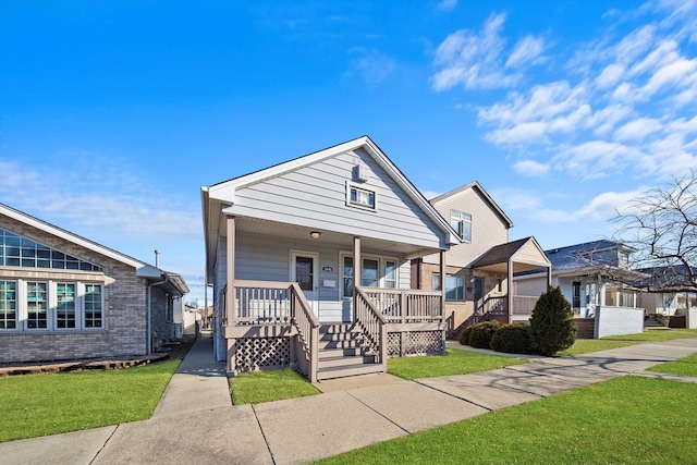 bungalow-style home featuring brick siding, covered porch, and a front lawn