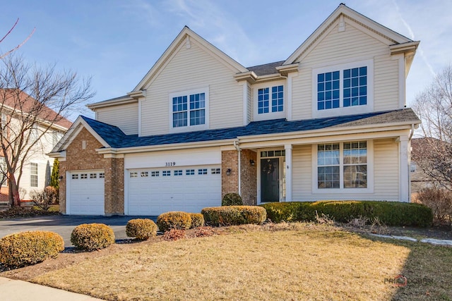 view of front of property featuring aphalt driveway, an attached garage, brick siding, and roof with shingles