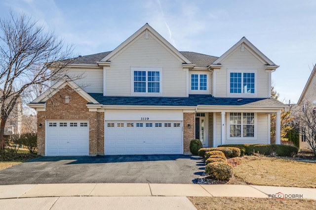 traditional home featuring a garage, brick siding, roof with shingles, and driveway