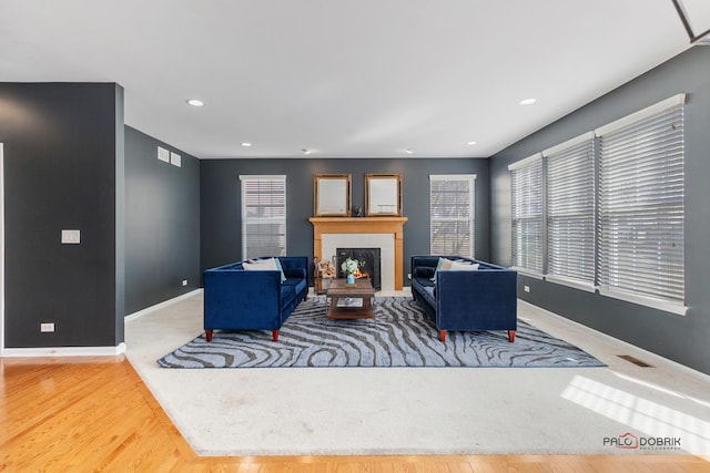 living area with recessed lighting, a fireplace, and baseboards