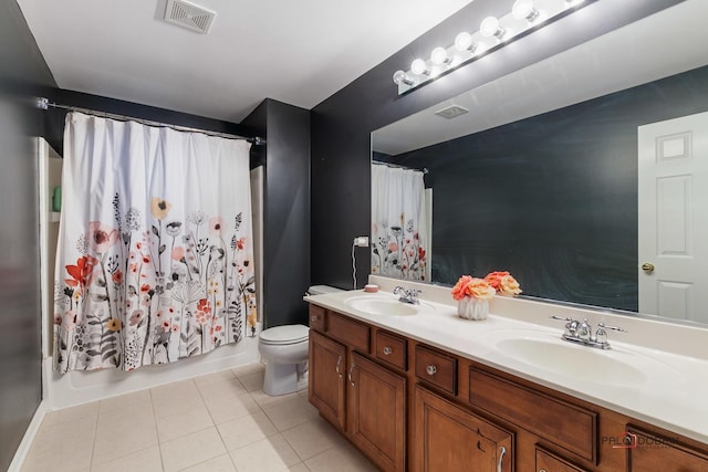 bathroom with tile patterned flooring, toilet, visible vents, and a sink