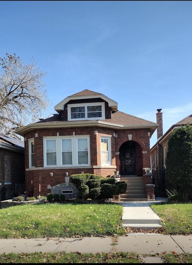 view of front facade featuring brick siding and a front lawn