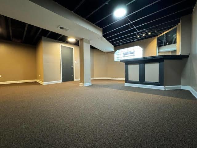 below grade area with carpet flooring, baseboards, and visible vents