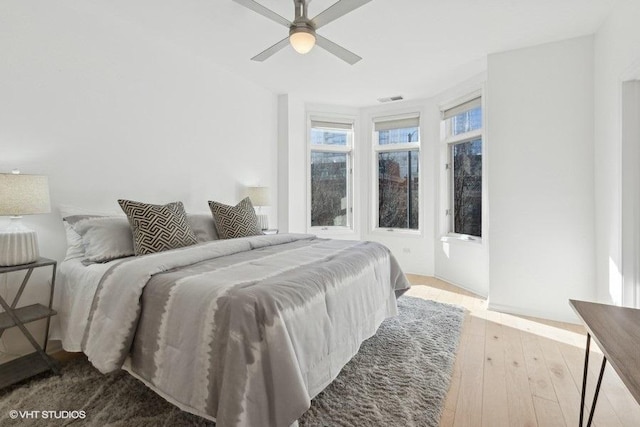 bedroom with visible vents, wood-type flooring, and ceiling fan