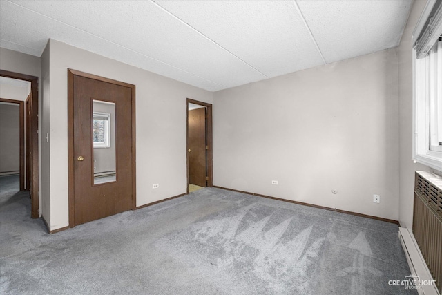 unfurnished bedroom featuring radiator, baseboards, and carpet floors