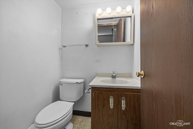 bathroom featuring baseboards, toilet, and vanity