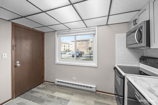 kitchen featuring stainless steel microwave, baseboard heating, light wood-style flooring, electric stove, and a paneled ceiling