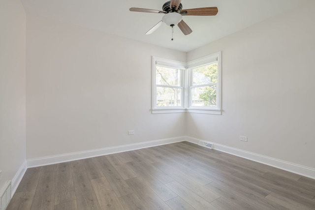unfurnished room featuring baseboards, wood finished floors, and a ceiling fan