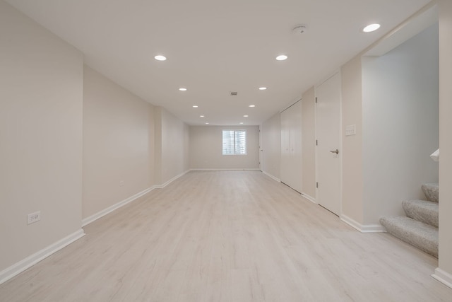 basement with recessed lighting, baseboards, light wood finished floors, and stairway