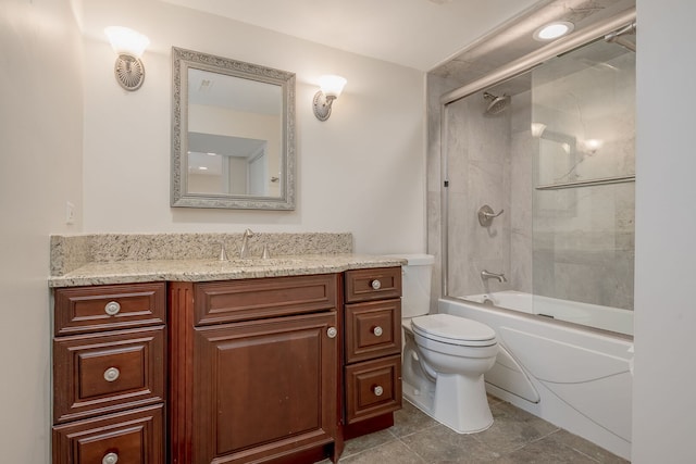 bathroom featuring toilet, vanity, bath / shower combo with glass door, and tile patterned floors