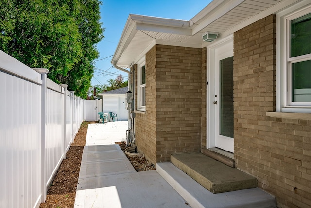 view of side of property featuring brick siding and a fenced backyard