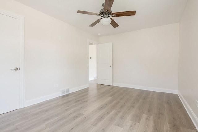 spare room featuring light wood finished floors, baseboards, and a ceiling fan