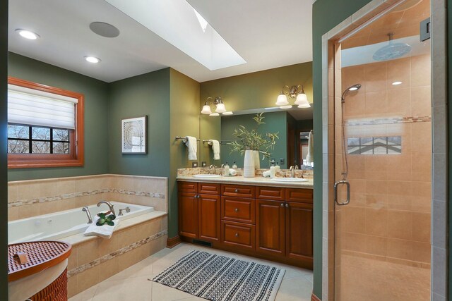 bathroom with a skylight, a sink, tile patterned flooring, a shower stall, and a bath