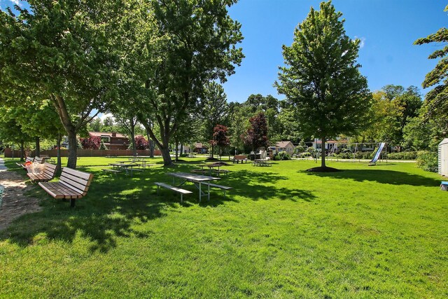 view of home's community featuring playground community and a lawn