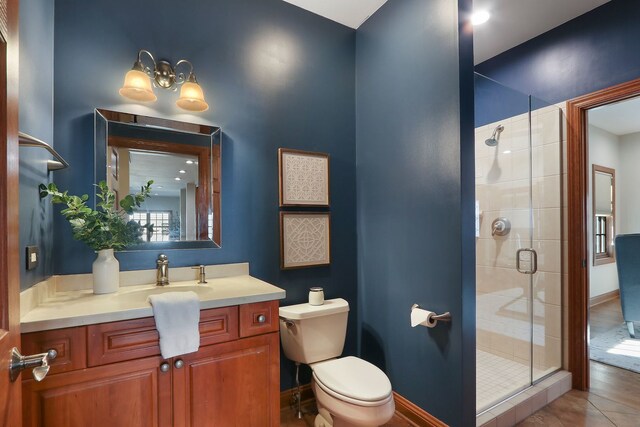 bathroom featuring vanity, baseboards, a shower stall, toilet, and a chandelier