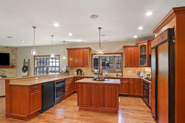 kitchen with black oven, a peninsula, high end fridge, and a healthy amount of sunlight