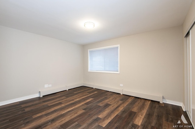 spare room with baseboards and dark wood-style flooring