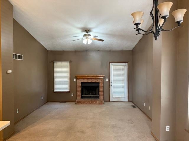 unfurnished living room with light carpet, visible vents, a brick fireplace, and a ceiling fan