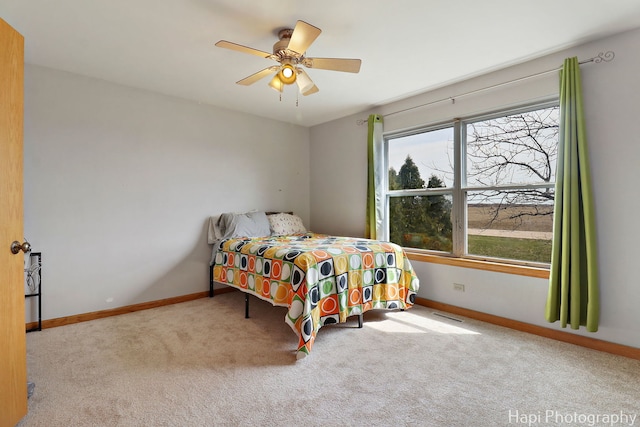 bedroom with carpet floors, a ceiling fan, visible vents, and baseboards
