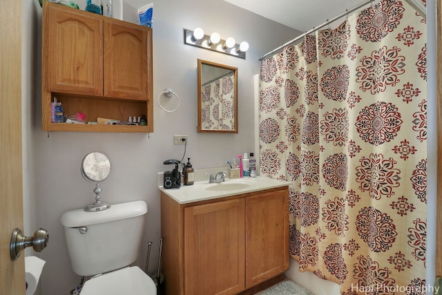 bathroom with toilet, vanity, and a shower with shower curtain