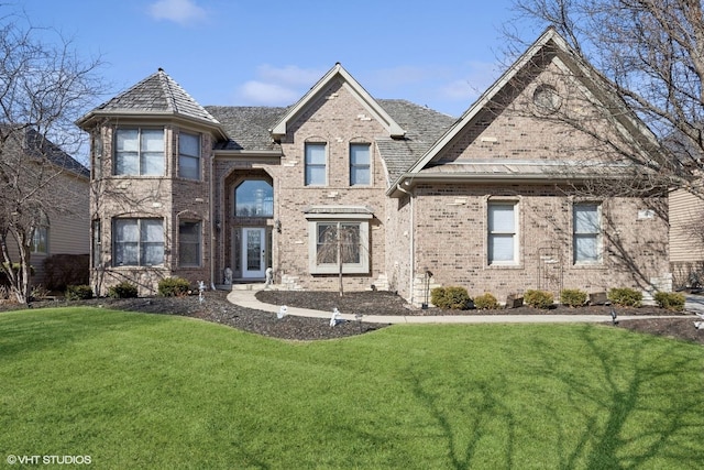 view of front of home featuring brick siding and a front lawn