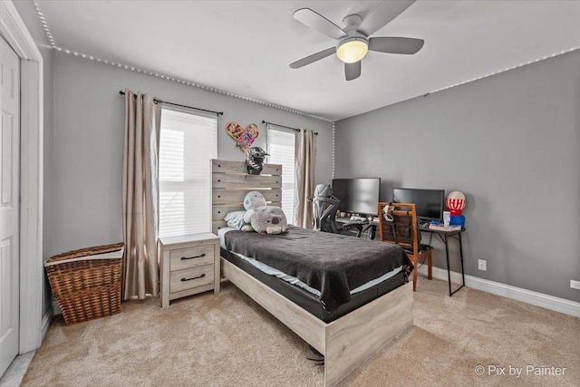 bedroom featuring light colored carpet, baseboards, and ceiling fan