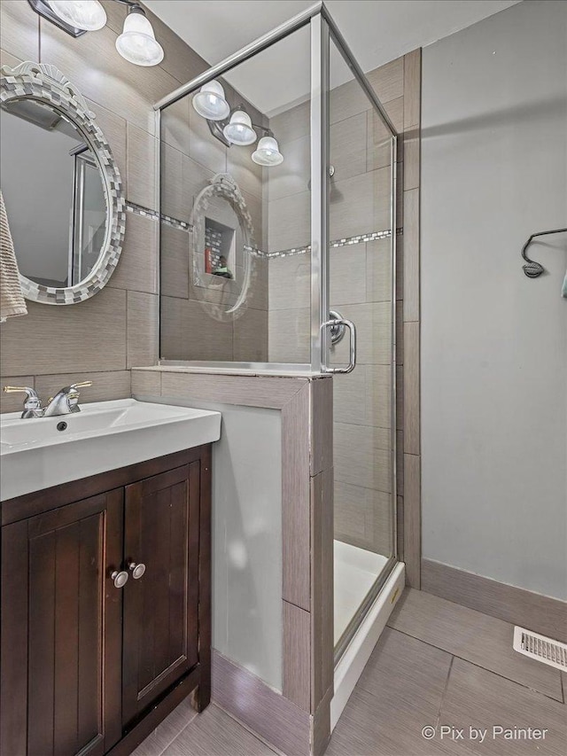 bathroom featuring tile patterned floors, vanity, and a shower stall