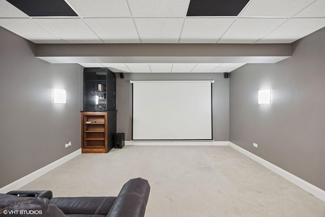 carpeted cinema featuring a paneled ceiling and baseboards