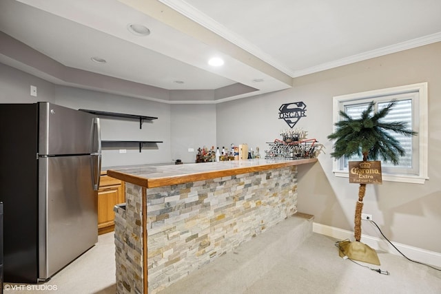 bar featuring ornamental molding, freestanding refrigerator, wet bar, baseboards, and light colored carpet