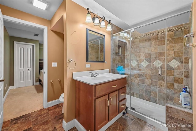 full bathroom with vanity, baseboards, a stall shower, stone finish floor, and toilet